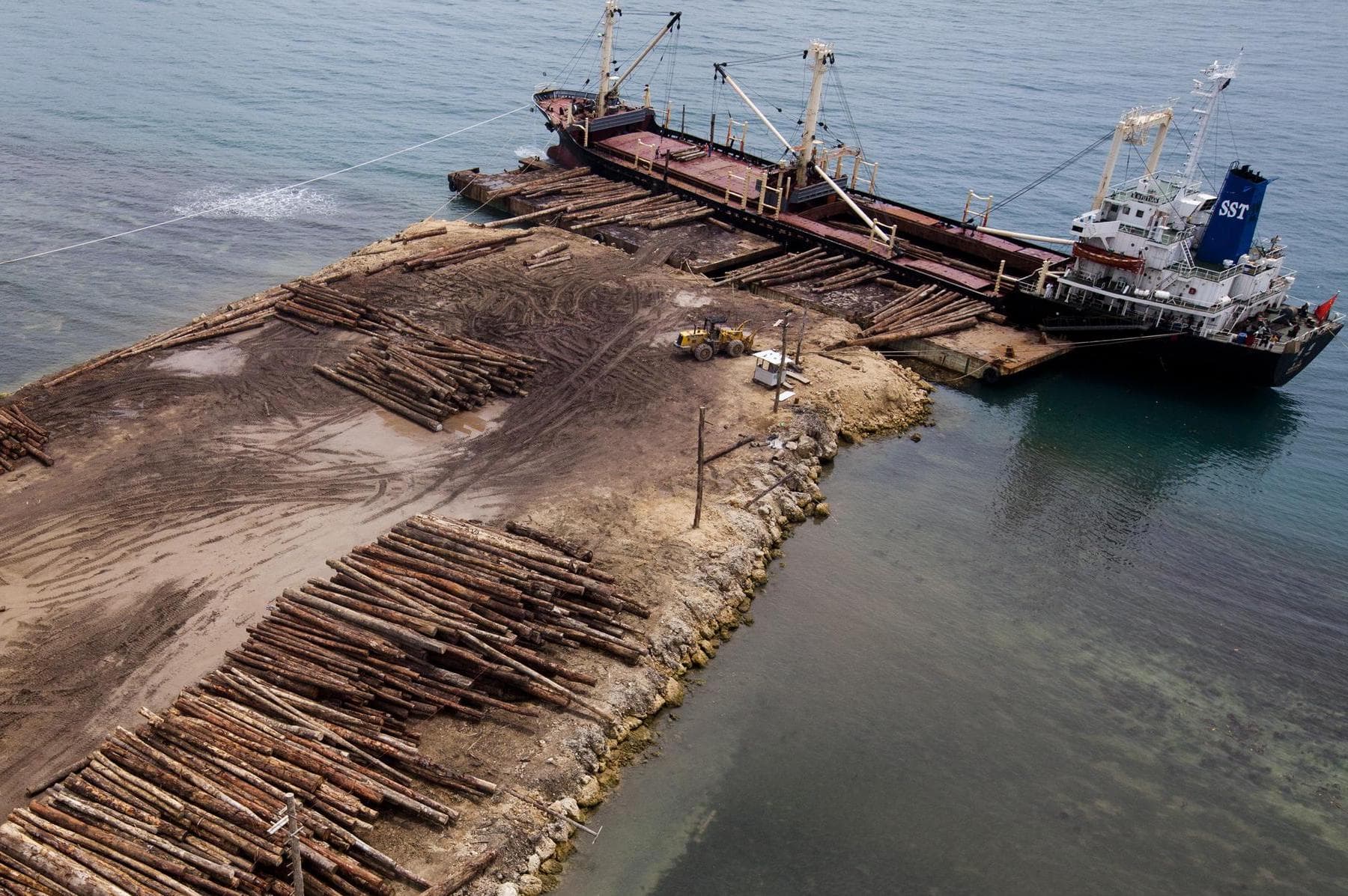 Logs being loaded onto a ship for export